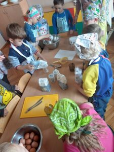 dzieci przygotowują ciasto na babeczki