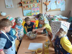 dzieci przygotowują ciasto na babeczki
