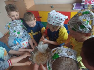 dzieci przygotowują ciasto na babeczki