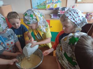 dzieci przygotowują ciasto na babeczki
