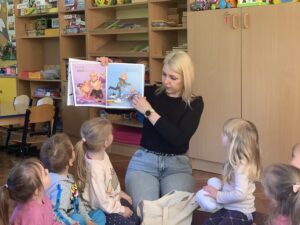 Pani bibliotekarka pokazuje dzieciom ilustracje