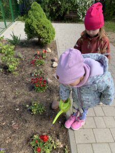 dziewczynka podlewa kwiaty