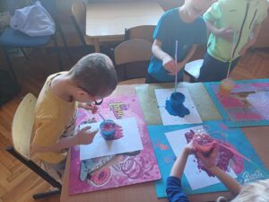 dzieci malujące za pomocą słomek