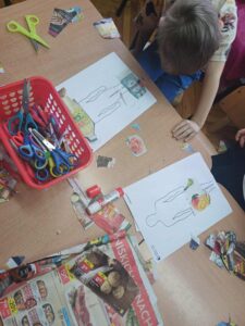 dzieci układają produkty z piramidy żywieniowej na posturze człowieka