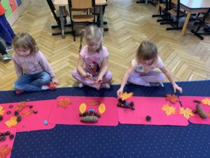 Dzieci układają obrazki z tworzywa przyrodniczego