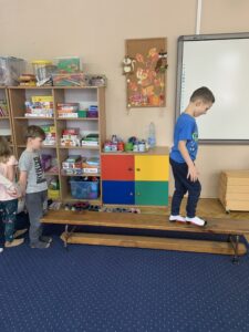 chłopiec stoi na ławeczce