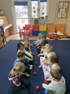 dzieci siedzą naprzeciwko siebie z woreczkami 